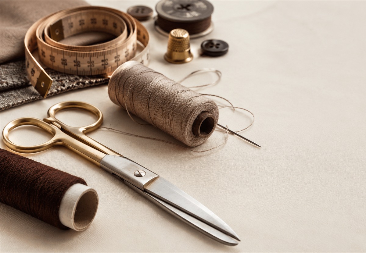 Tailoring scissors, measuring tape, thread, and alteration tools.