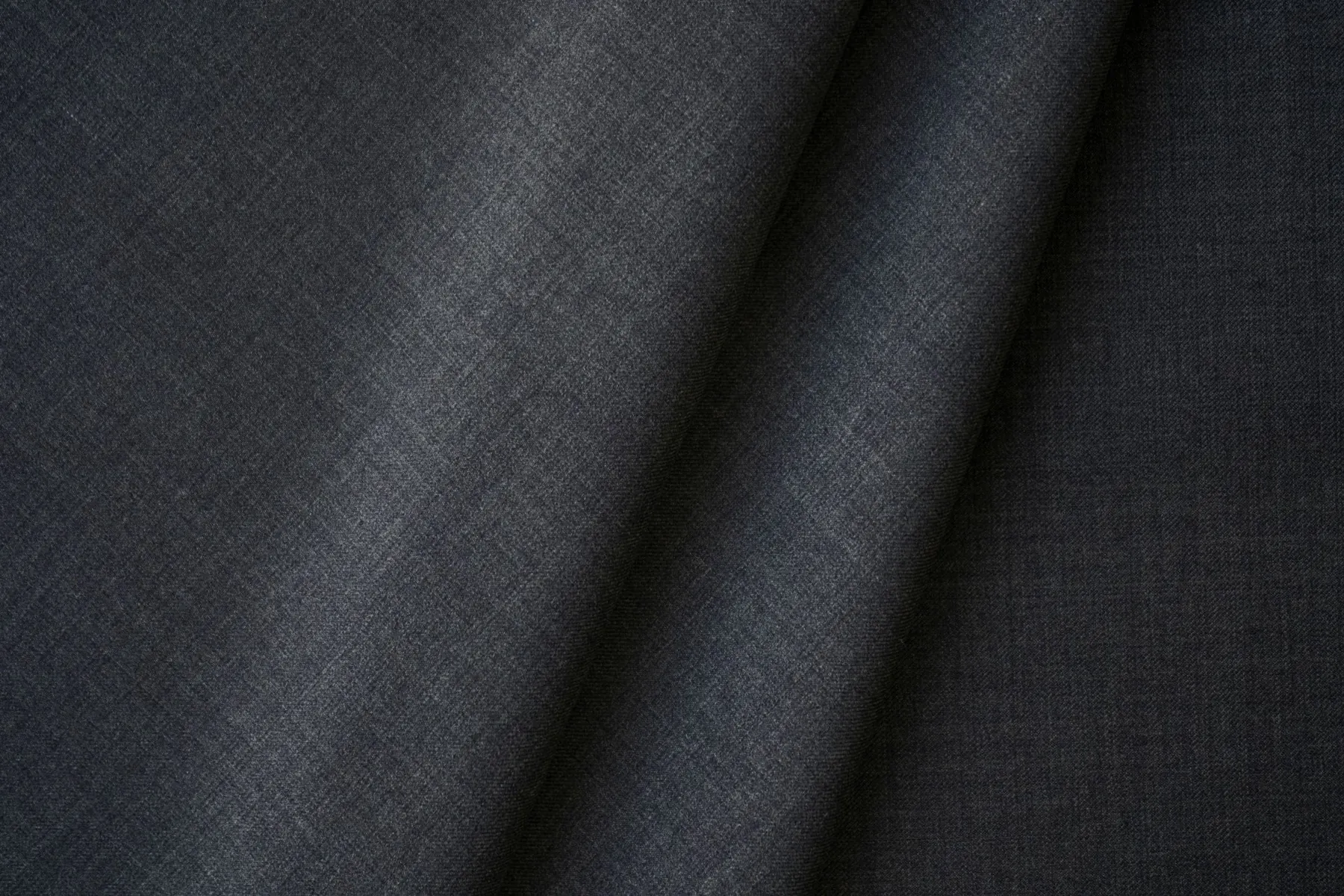 Illustrative close-up of woven navy cloth and a diagonal fold