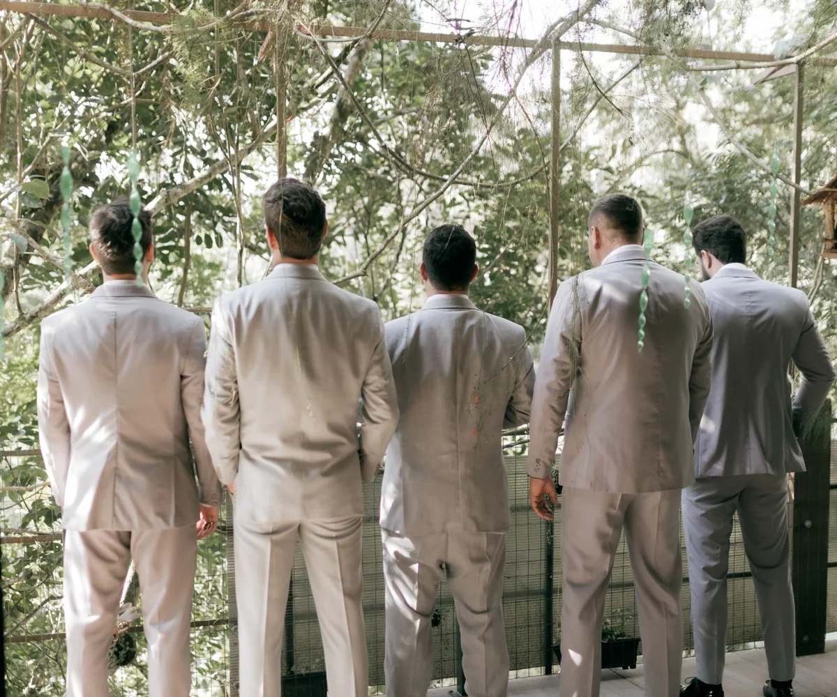 Illustrative group in grey suits seen from behind in a garden