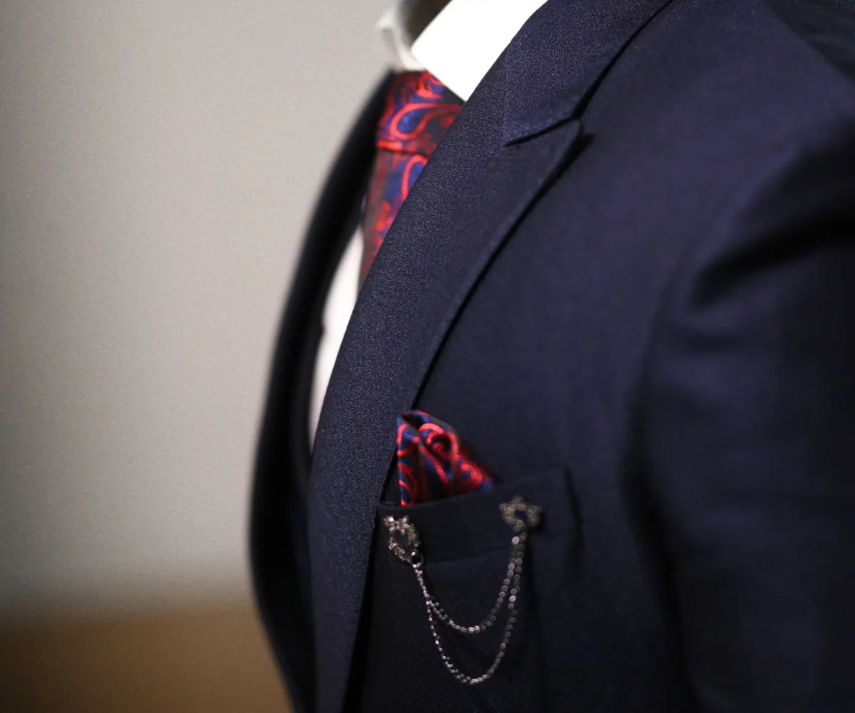 Illustrative navy suit lapel with a patterned tie and pocket square